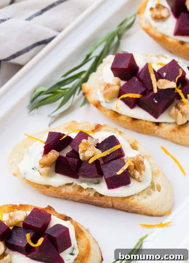 Exquisite beet bruschetta appetizers, featuring vibrant roasted beets atop toasted crostini, garnished with fresh orange zest and tarragon sprigs.