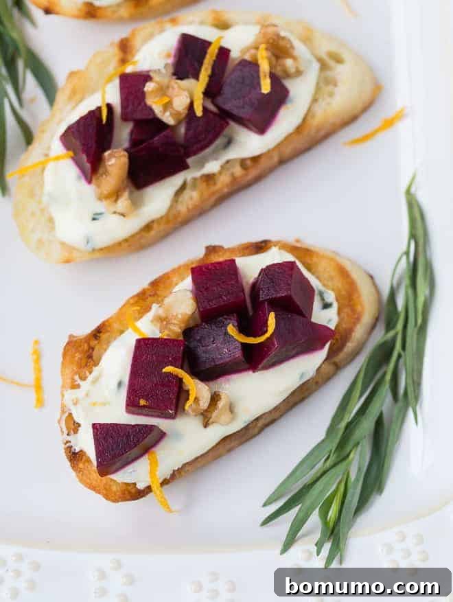 Beautifully arranged beet and goat cheese bruschetta, artfully garnished with crunchy walnuts and delicate orange zest, ready to serve.