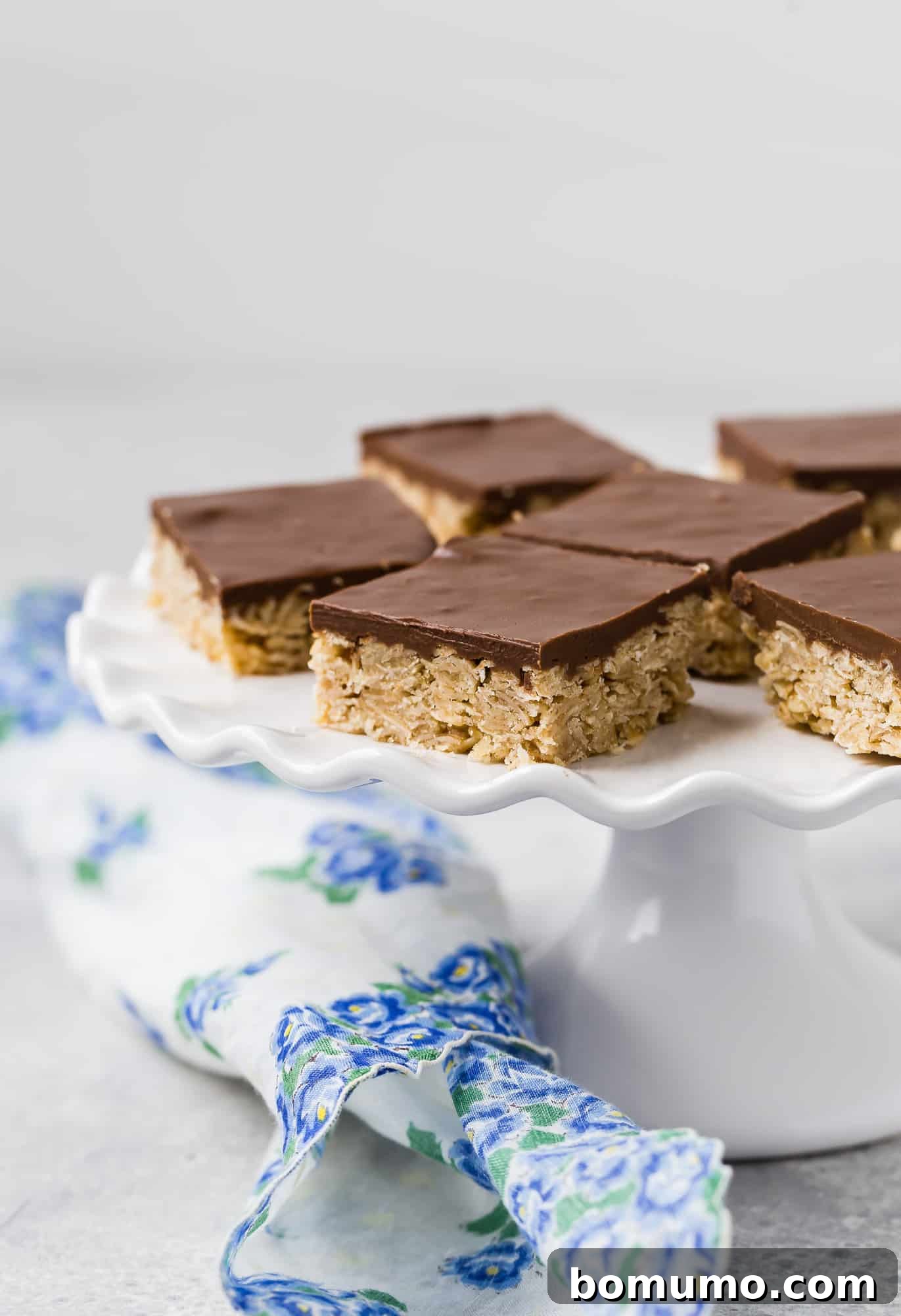 Oh Henry Bars Nut-Free Version Available 2 Oh Henry bars on a white cake stand, showcasing their delicious layers.