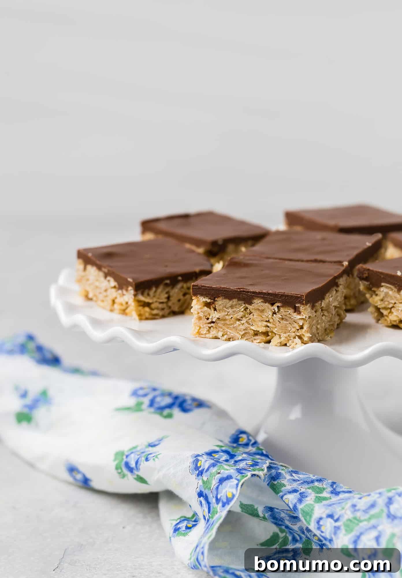 Oh Henry Bars Nut-Free Version Available 4 Chocolate and oat bars on a white ruffled edge cake stand, elegantly presented.