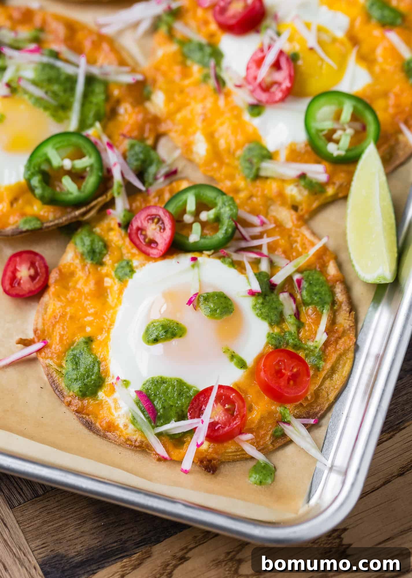 One-Pan Breakfast Tostadas 2 Crispy Sheet Pan Breakfast Tostada topped with a fried egg, melted cheese, and vibrant salsa verde, ready to be enjoyed.