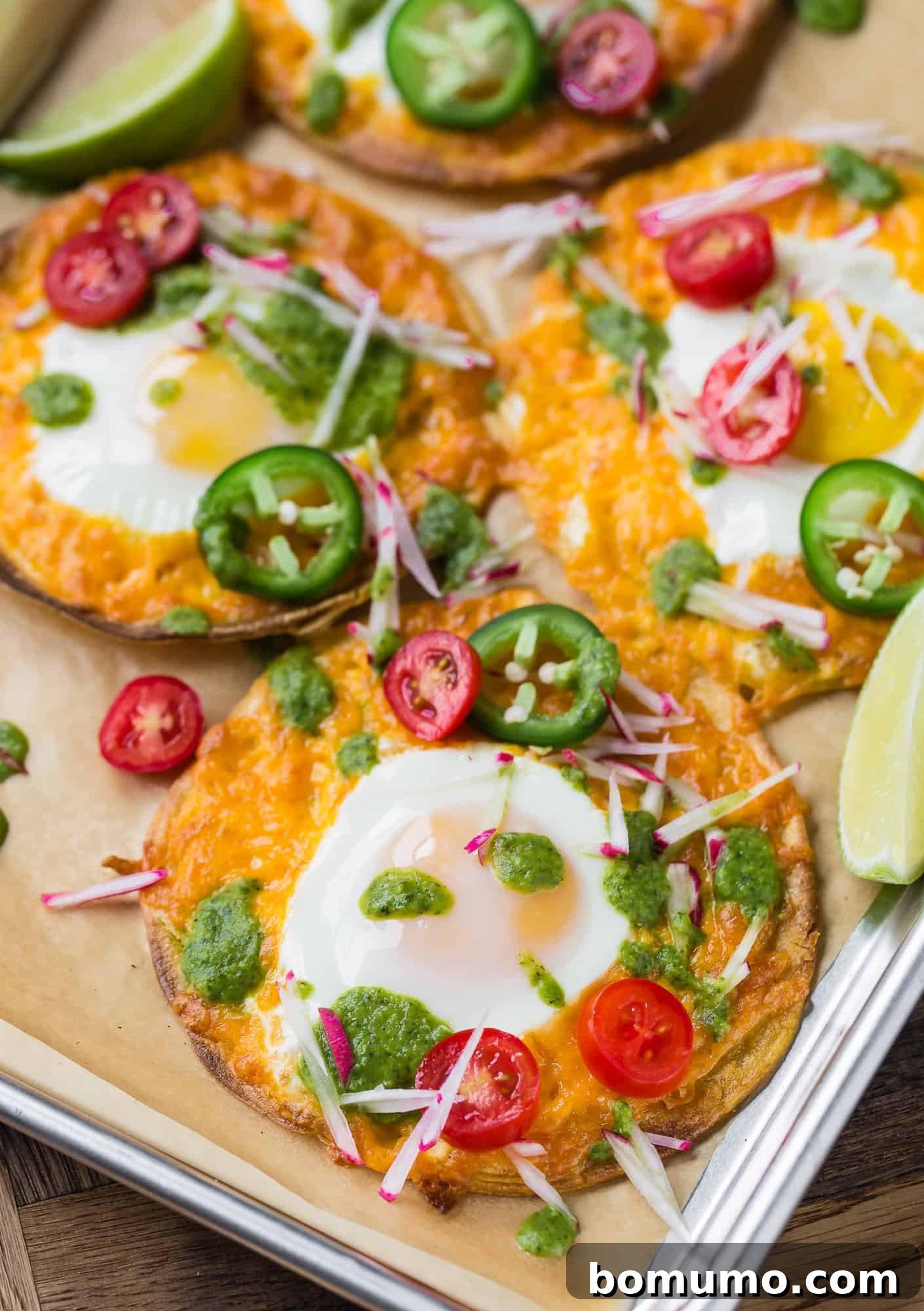 One-Pan Breakfast Tostadas 5 A delicious Sheet Pan Breakfast Tostada featuring a golden fried egg, melted cheese, fresh diced tomatoes, and a generous drizzle of salsa verde.