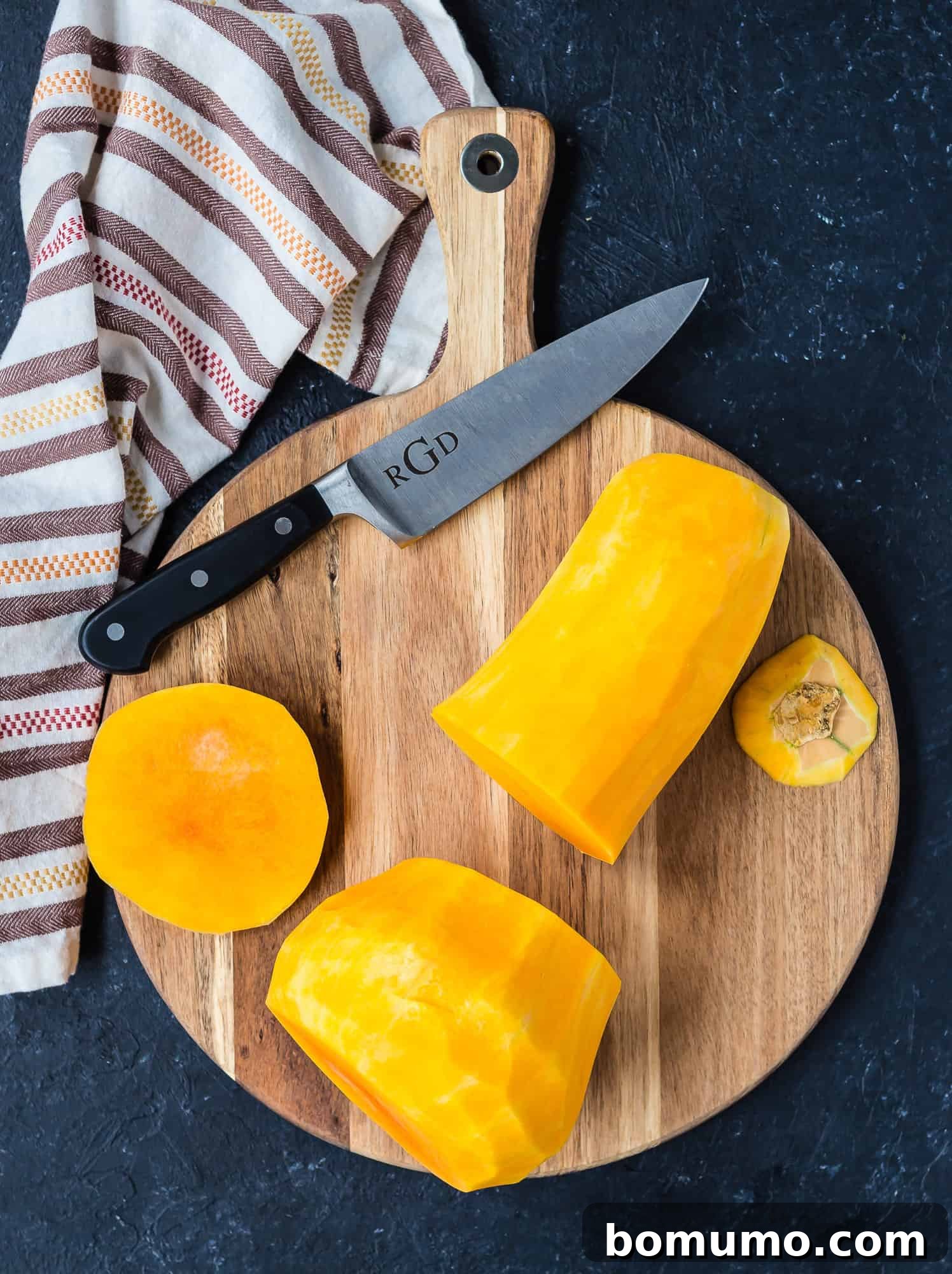 Peeled butternut squash, cut into two distinct sections: the neck and the bulb, with trimmed ends.