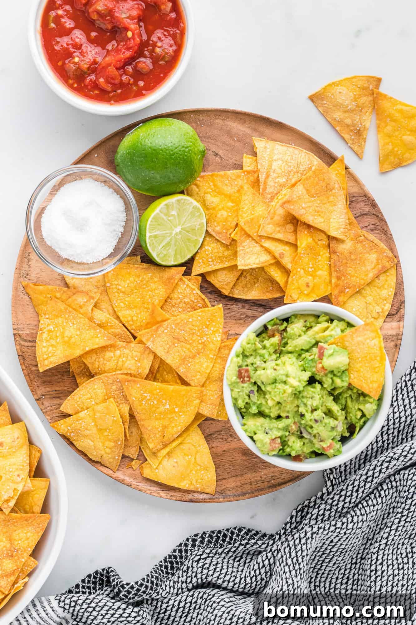 Corn-tortilla-chips-3 Crispy baked tortilla chips served with vibrant green guacamole and chunky red salsa, ready for dipping.