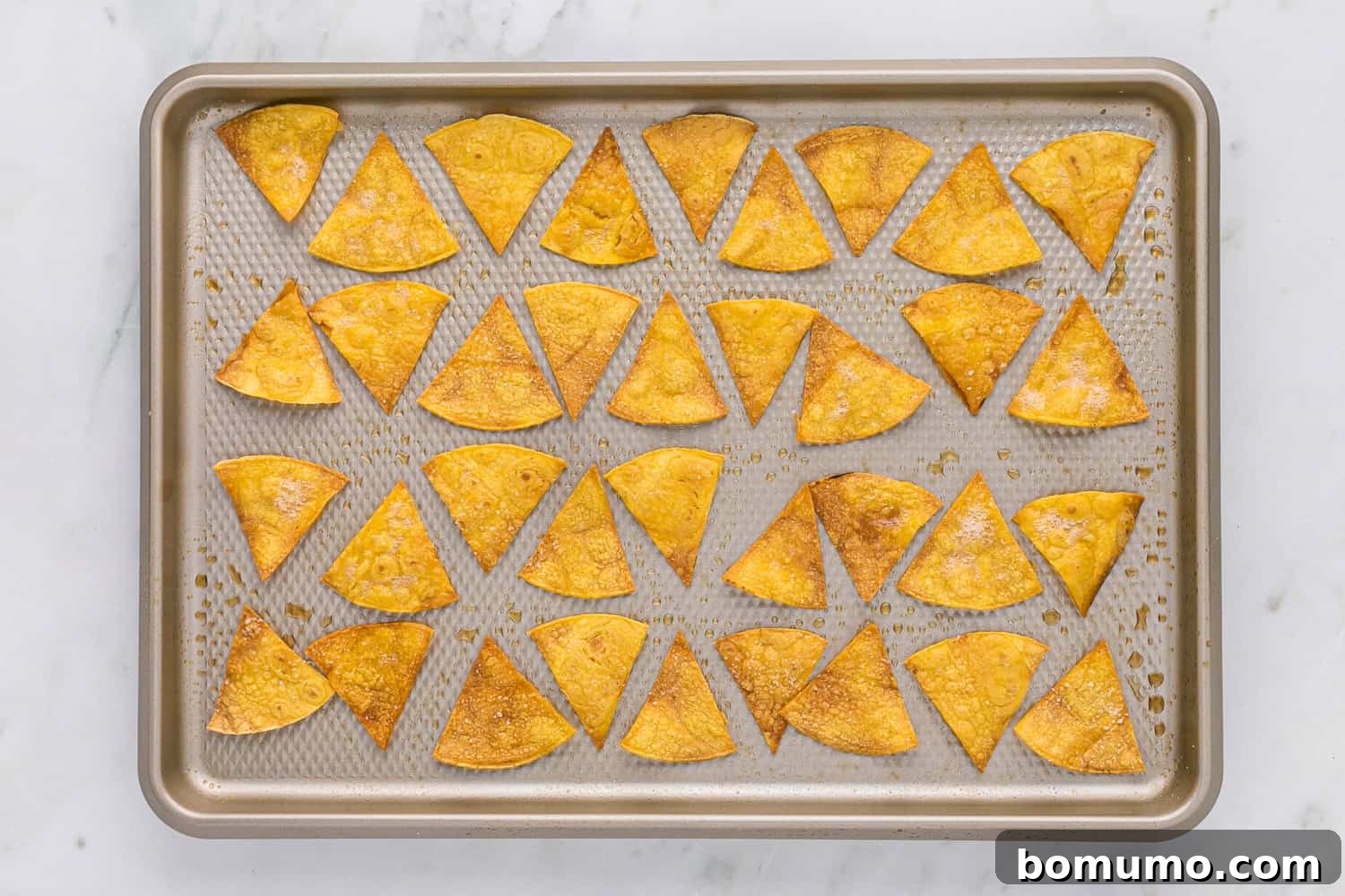 Crispy Oven Tortillas 6 A baking sheet filled with freshly baked, golden-brown tortilla chips, indicating perfect crispness.