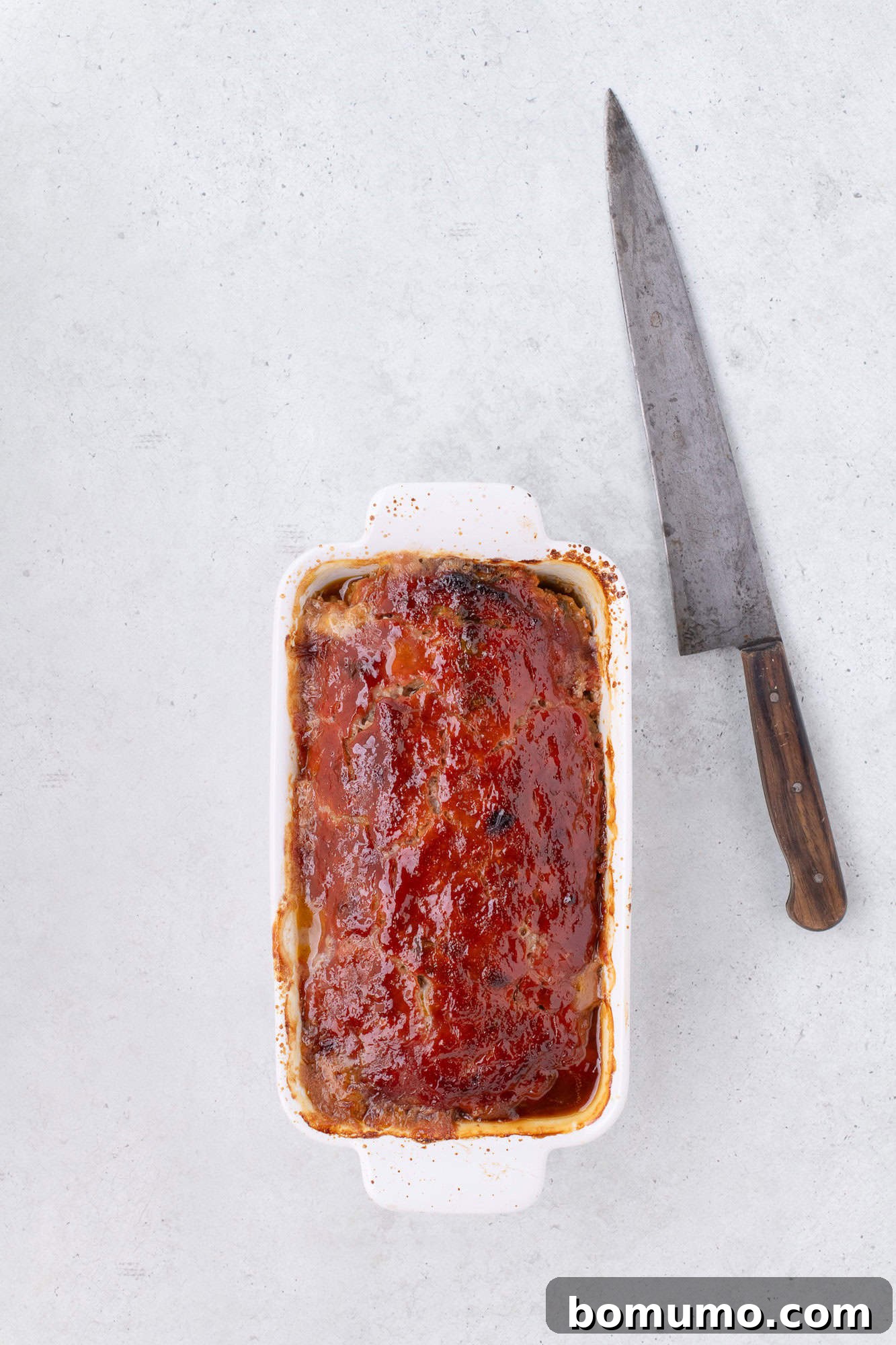 A perfectly baked classic meatloaf, glistening with its caramelized glaze, fresh out of the oven.