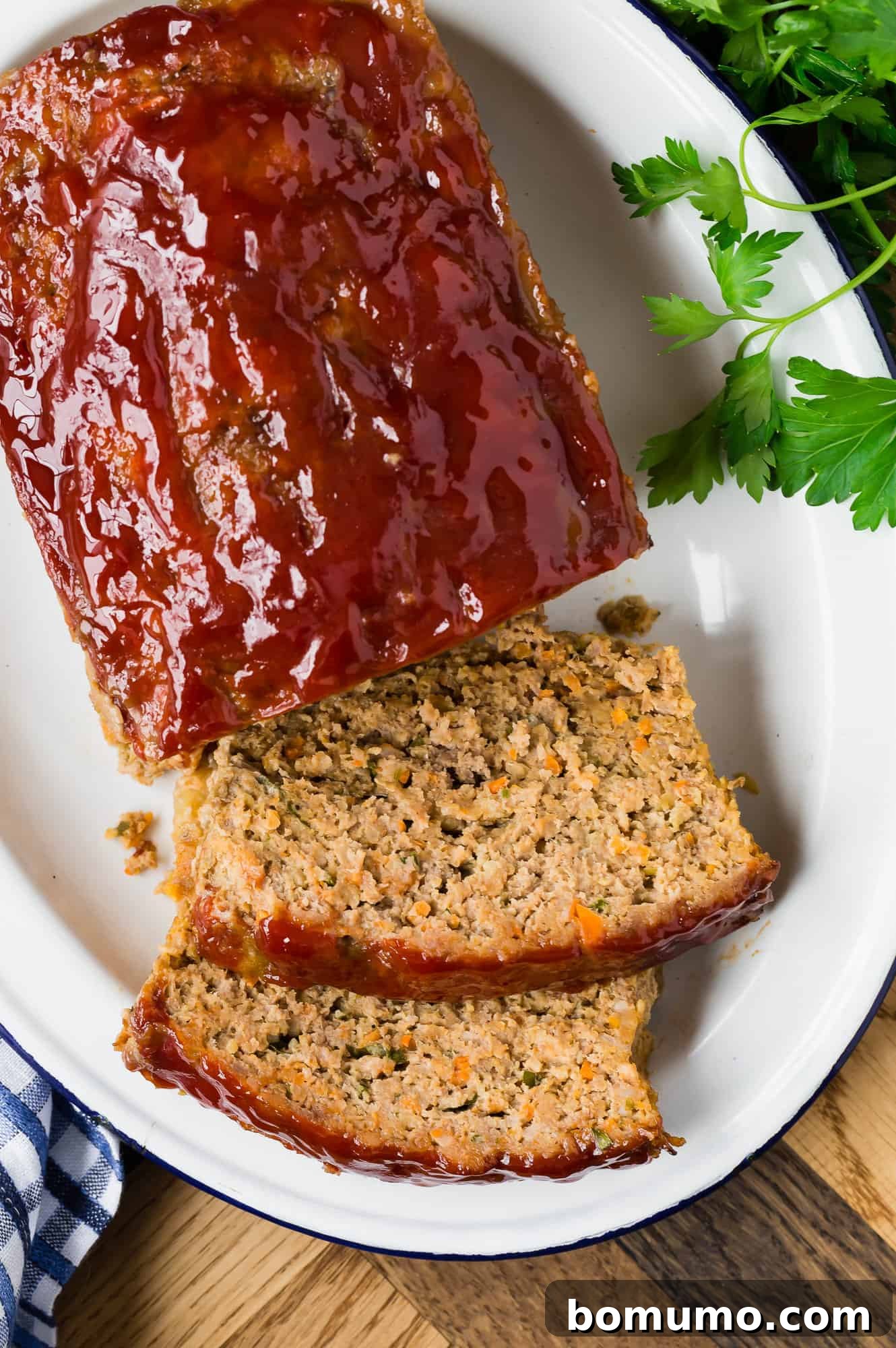 Overhead view of a perfectly baked and partially sliced meatloaf, ready to be served.