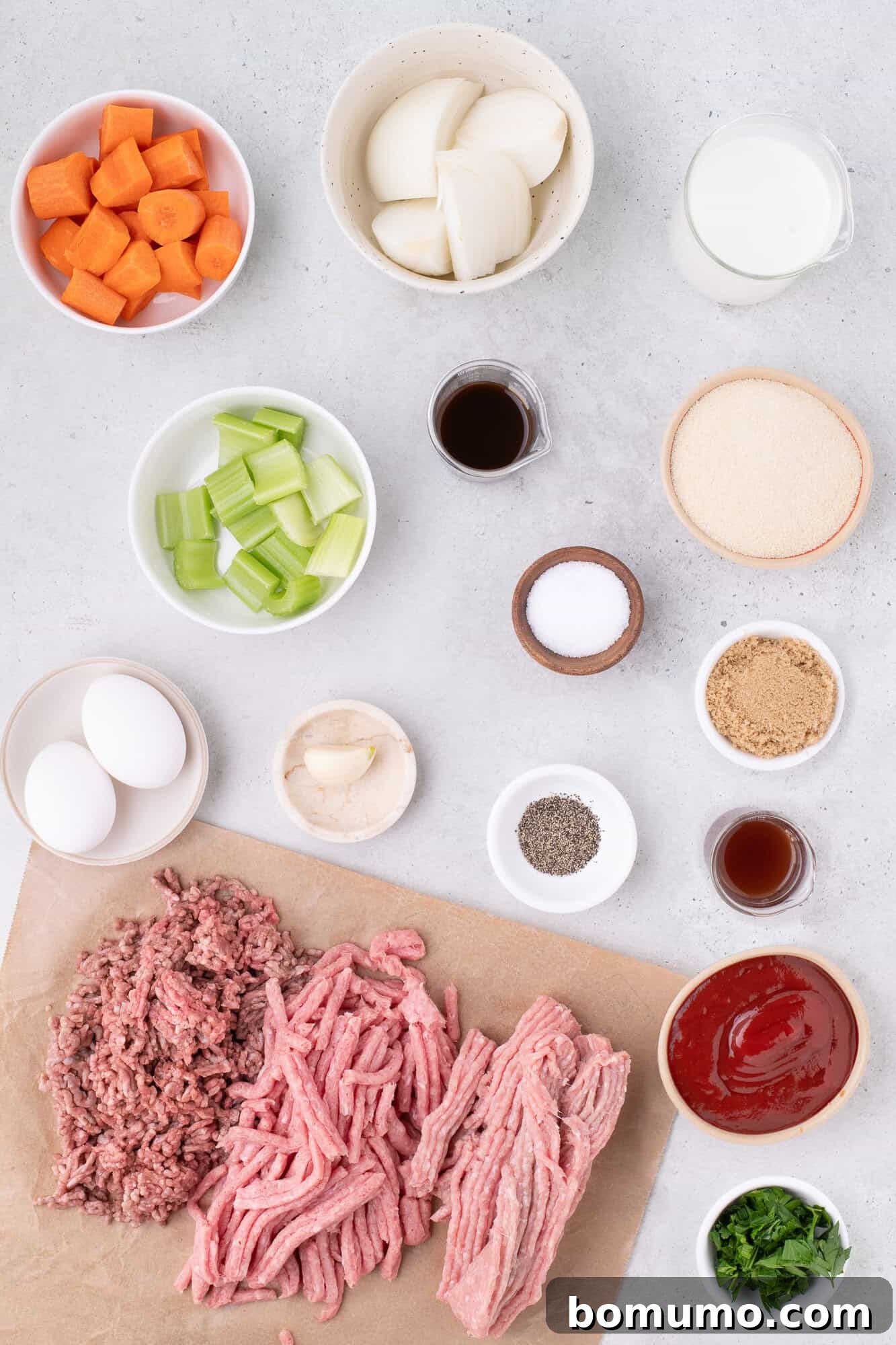 Overhead view of all fresh ingredients carefully laid out, ready for preparing classic meatloaf.