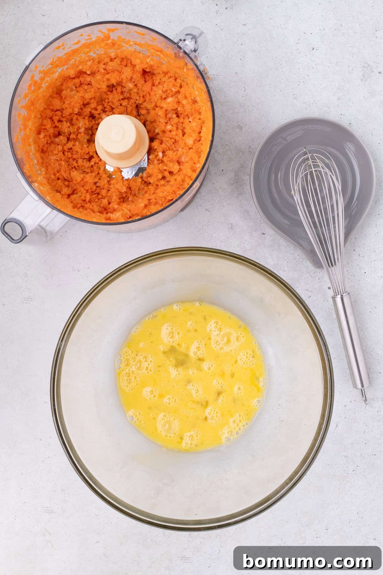 Lightly beaten eggs in a large mixing bowl, forming a smooth base for the meatloaf.