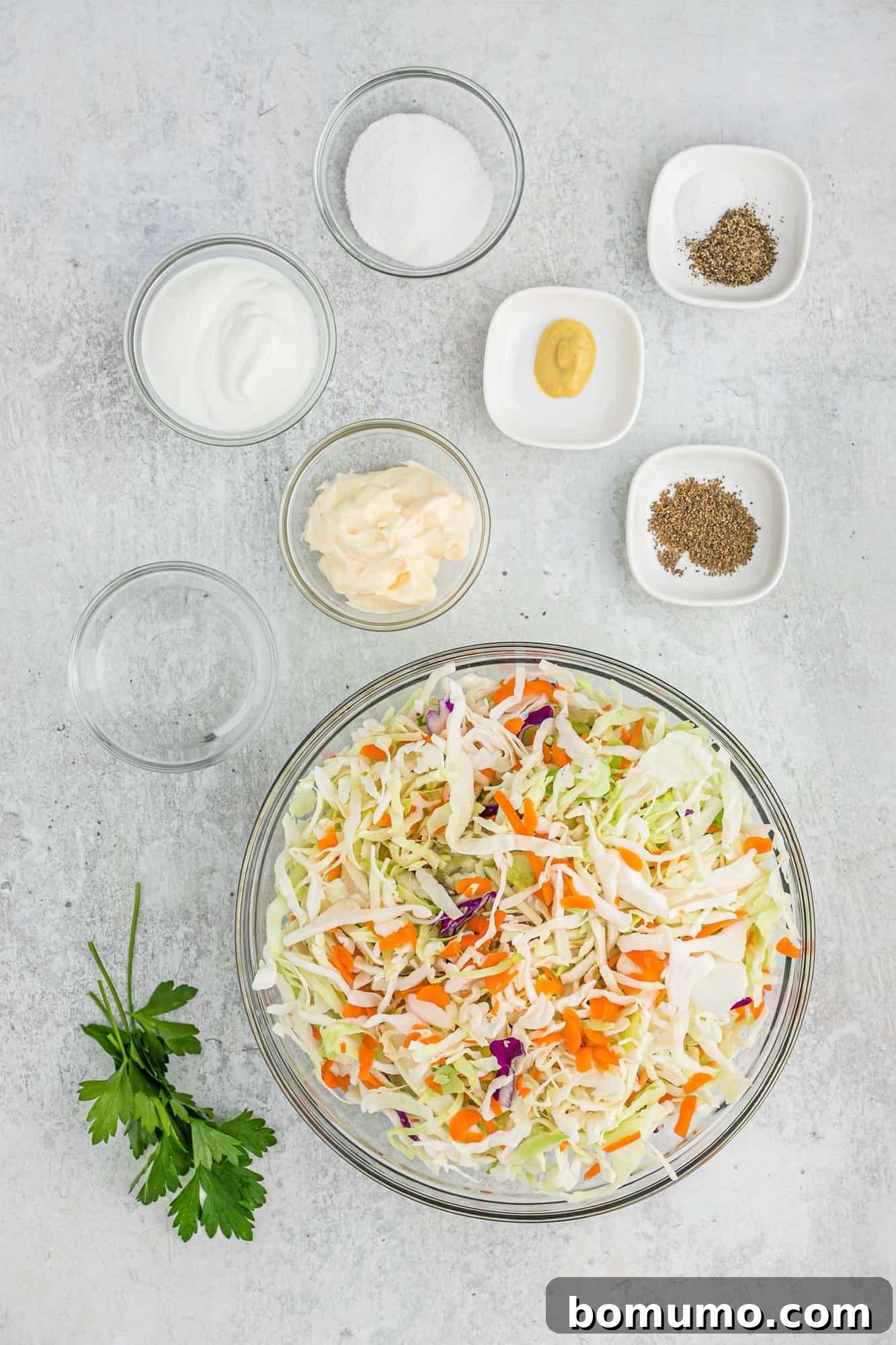Ingredients in separate bowls, including shredded cabbage and carrots, ready for mixing.