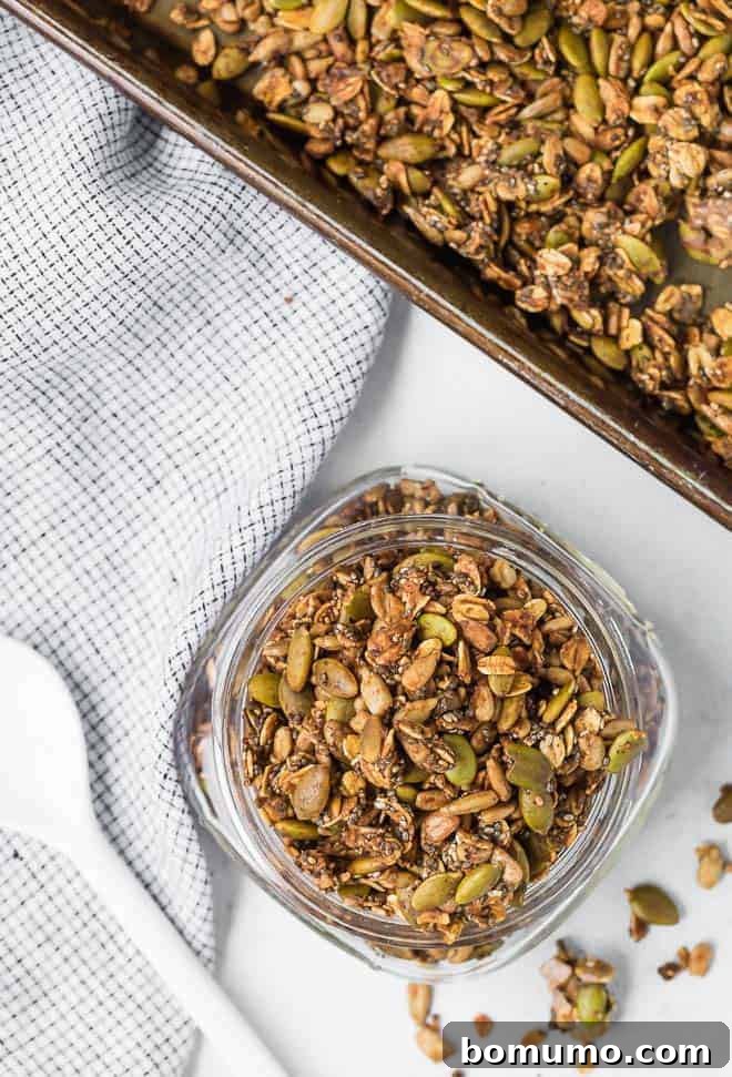 Image of nut free granola made with seeds and oats, spread out on a white surface.