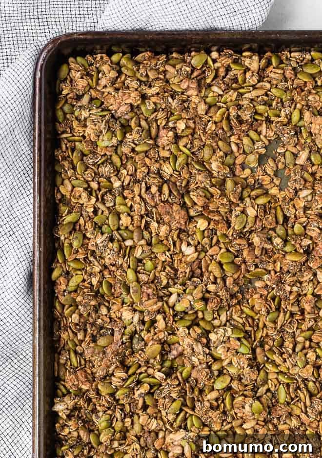 Image of savory granola on a large sheet pan, fresh out of the oven and perfectly golden brown.