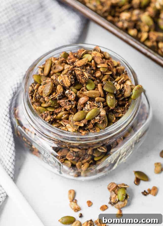 Image of homemade savory granola in a clear glass jar, ready for storage or serving.