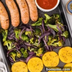 Sheet pan Italian sausage, roasted broccoli, and creamy polenta, with a side of savory tomato sauce.