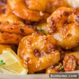 Close up of cooked shrimp with spicy honey sauce and bits of crunchy garlic.