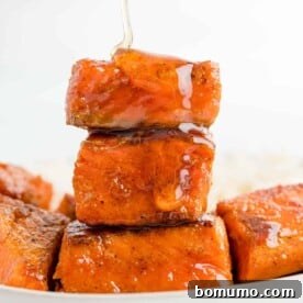 A stack of salmon bites being drizzled with hot honey.