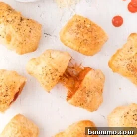 Overhead view of homemade hot pockets, one being pulled apart to show filling, a great kid-friendly meal.
