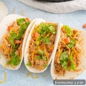 Three chicken tacos topped with lettuce and tomatoes, a simple 3-ingredient meal.