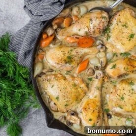 Chicken fricassee in a black skillet.