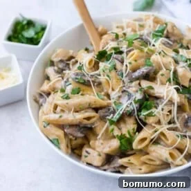 Chicken marsala pasta with a wooden spoon.
