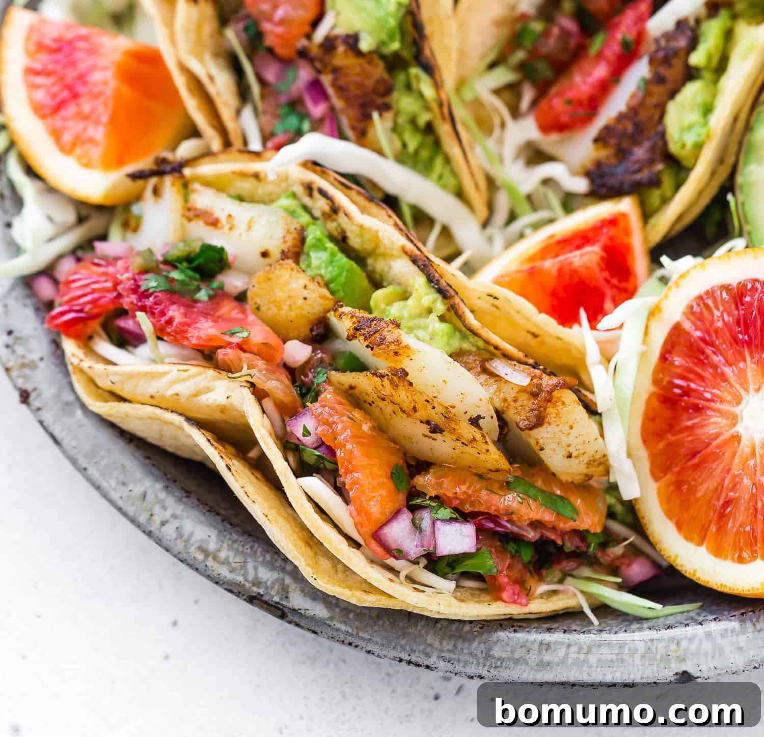 Close up of a perfectly assembled fish taco in a double corn tortilla.