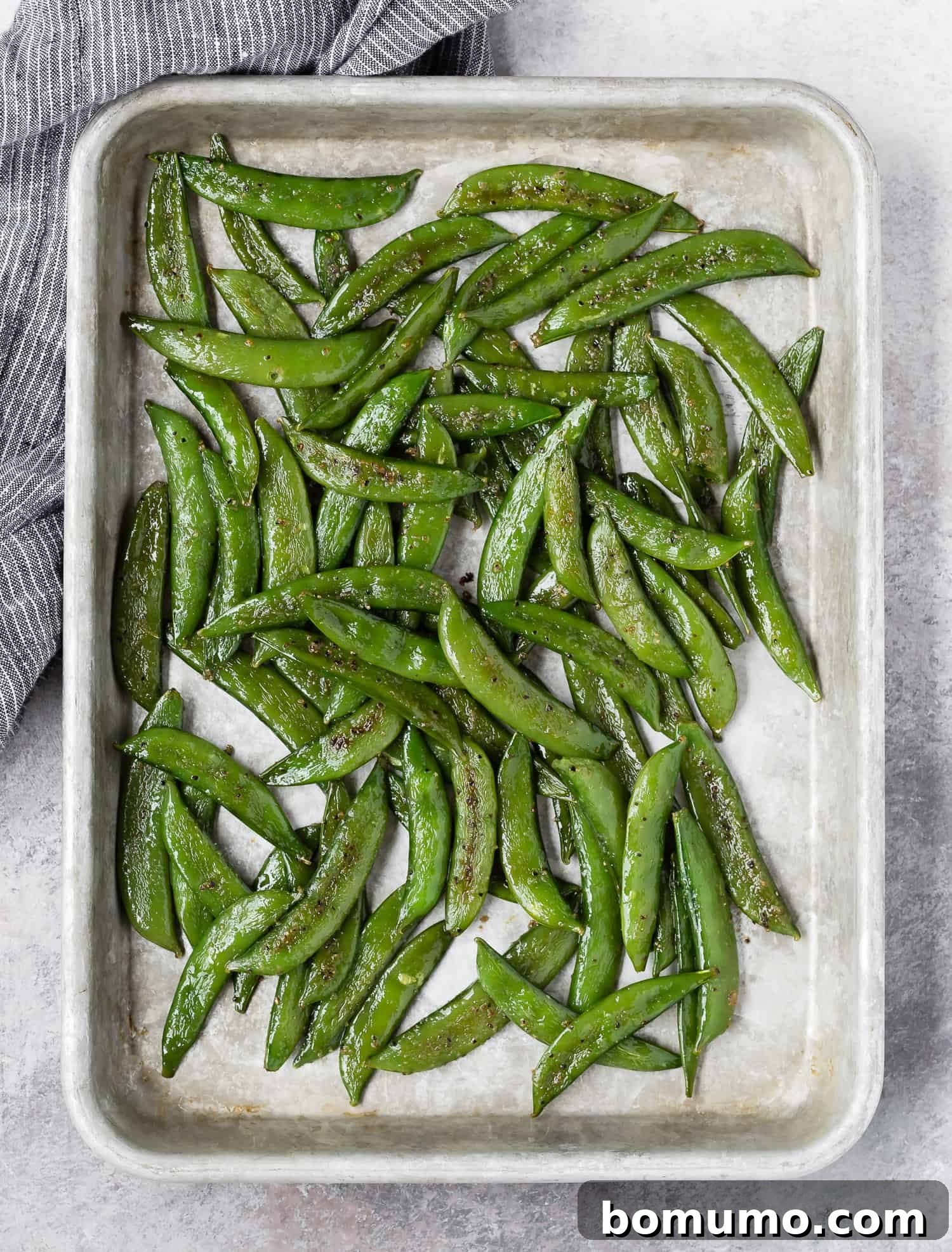 Crispy Roasted Sugar Snap Peas 4 Overhead view of a sheet pan with perfectly roasted sugar snap peas on it.