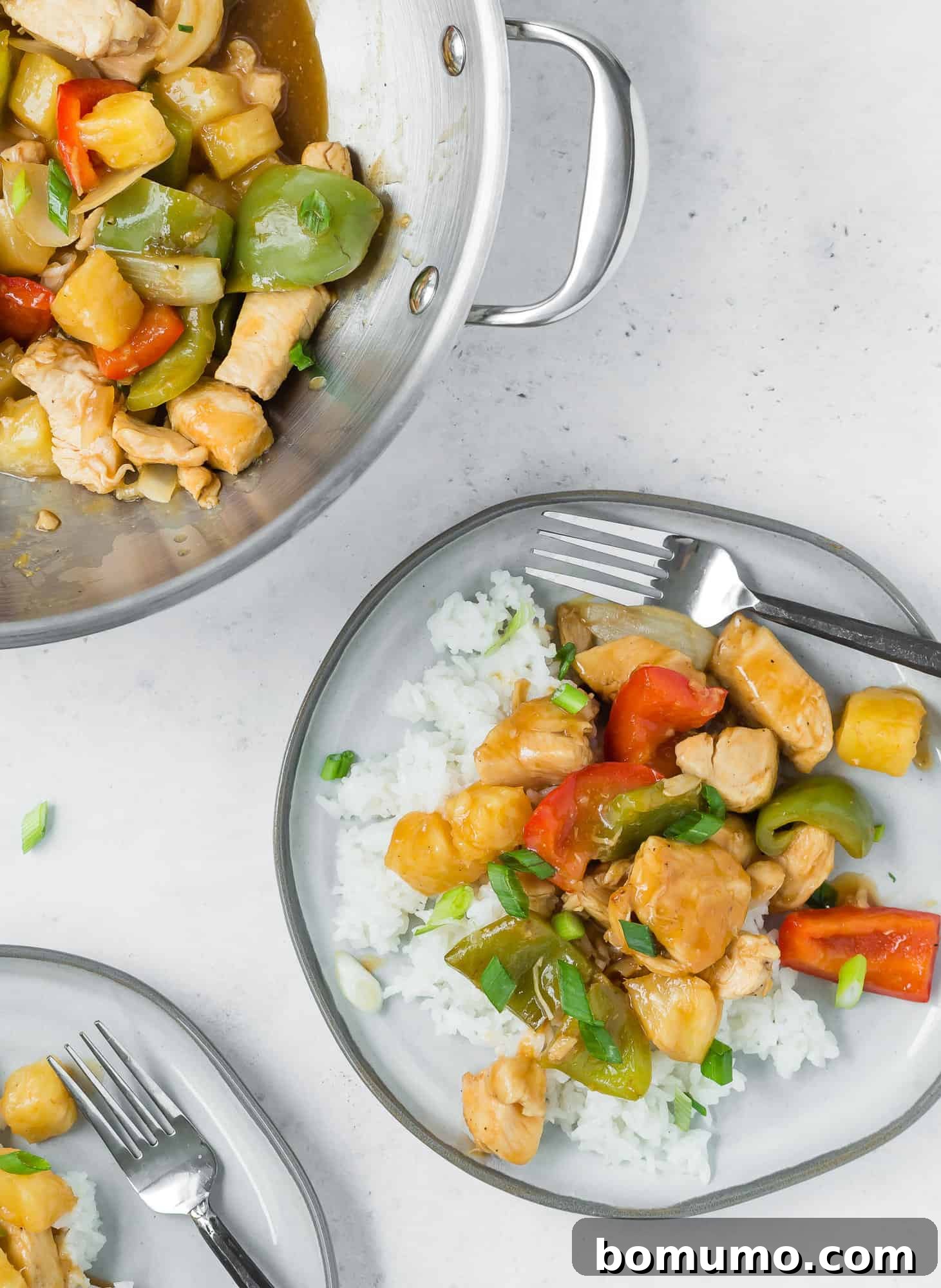 Two plates of sweet and sour chicken on rice.