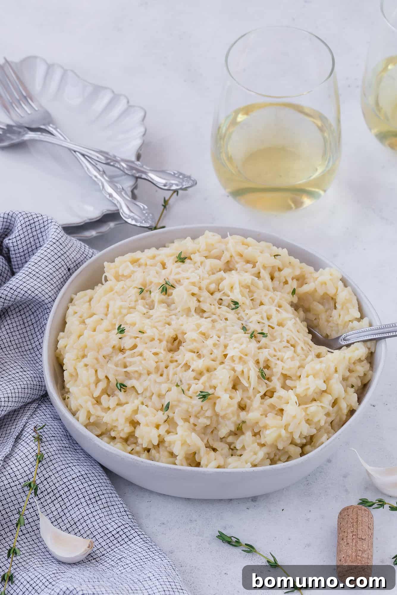Risotto in a bowl with wine in background.
