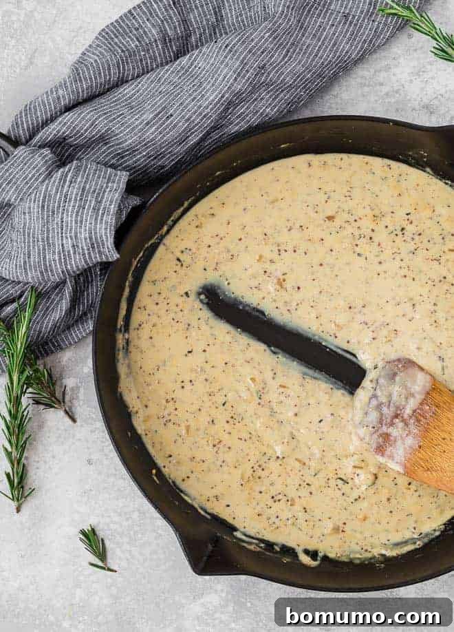 Image of luscious creamy Dijon sauce being stirred in a frying pan with a wooden spoon.