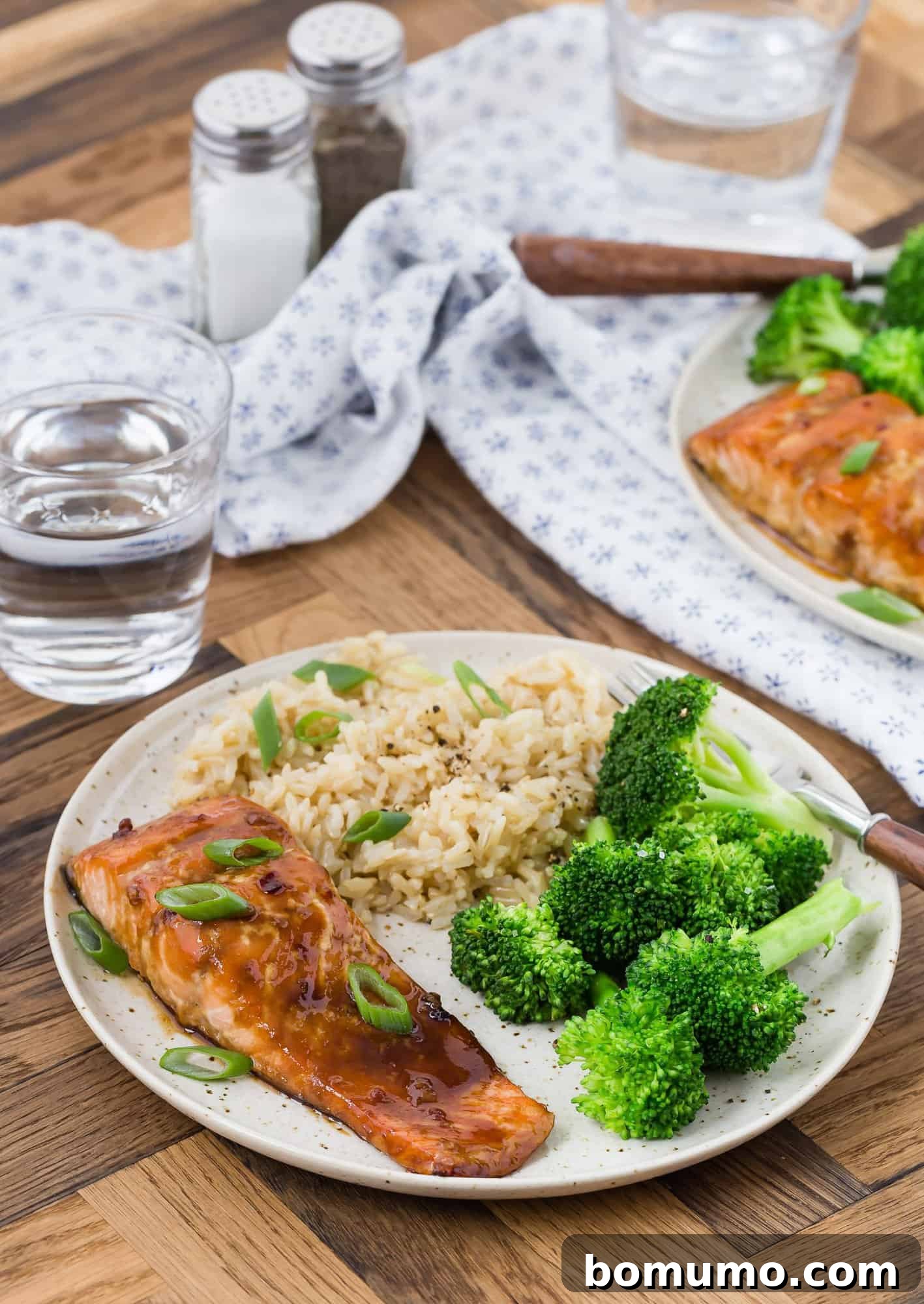 Salmon glazed with honey and soy on a plate with fresh broccoli florets and fluffy white rice, ready to be enjoyed.