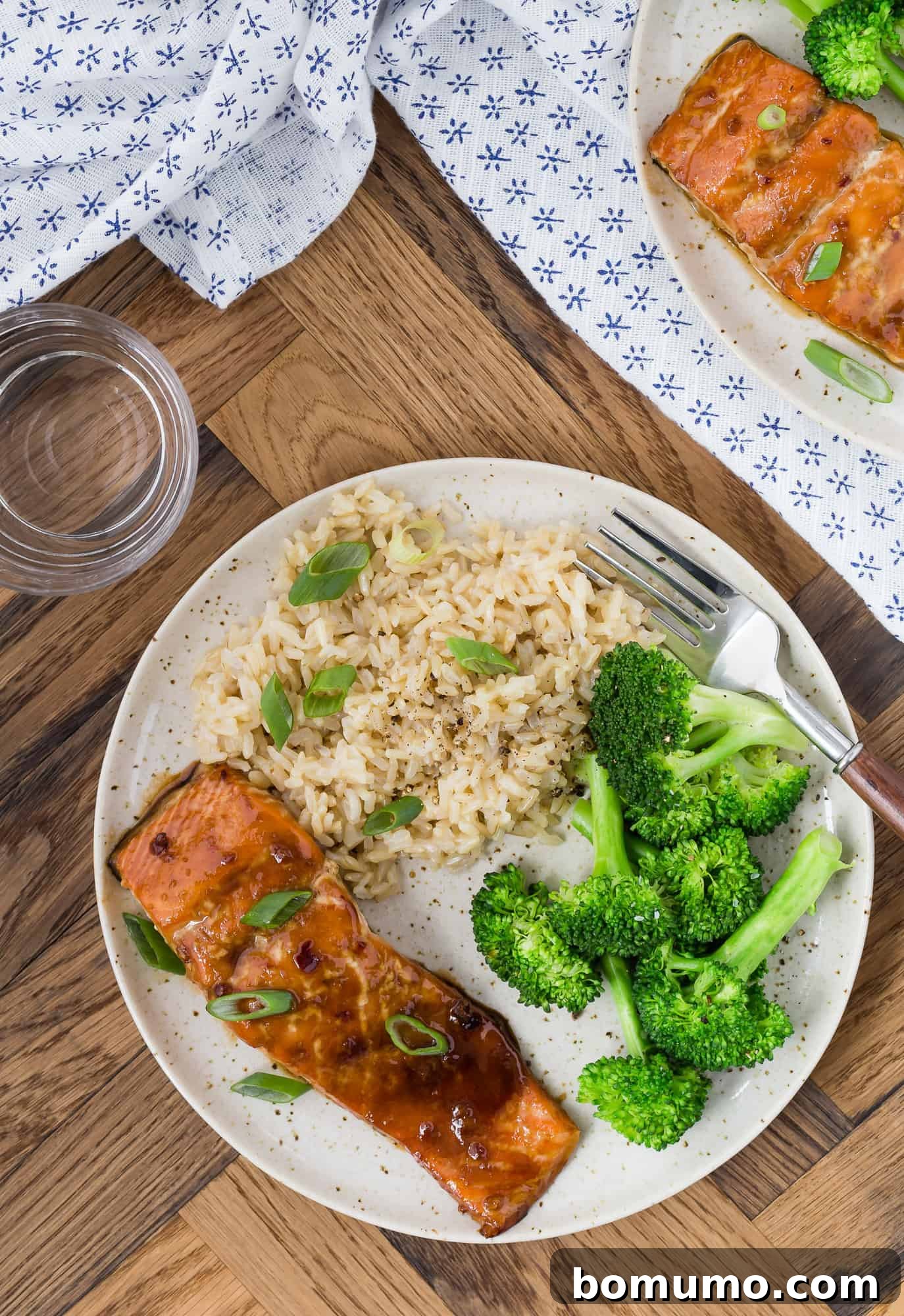 Soy and honey glazed salmon served on a plate with steamed broccoli and brown rice, creating a wholesome and appealing meal.