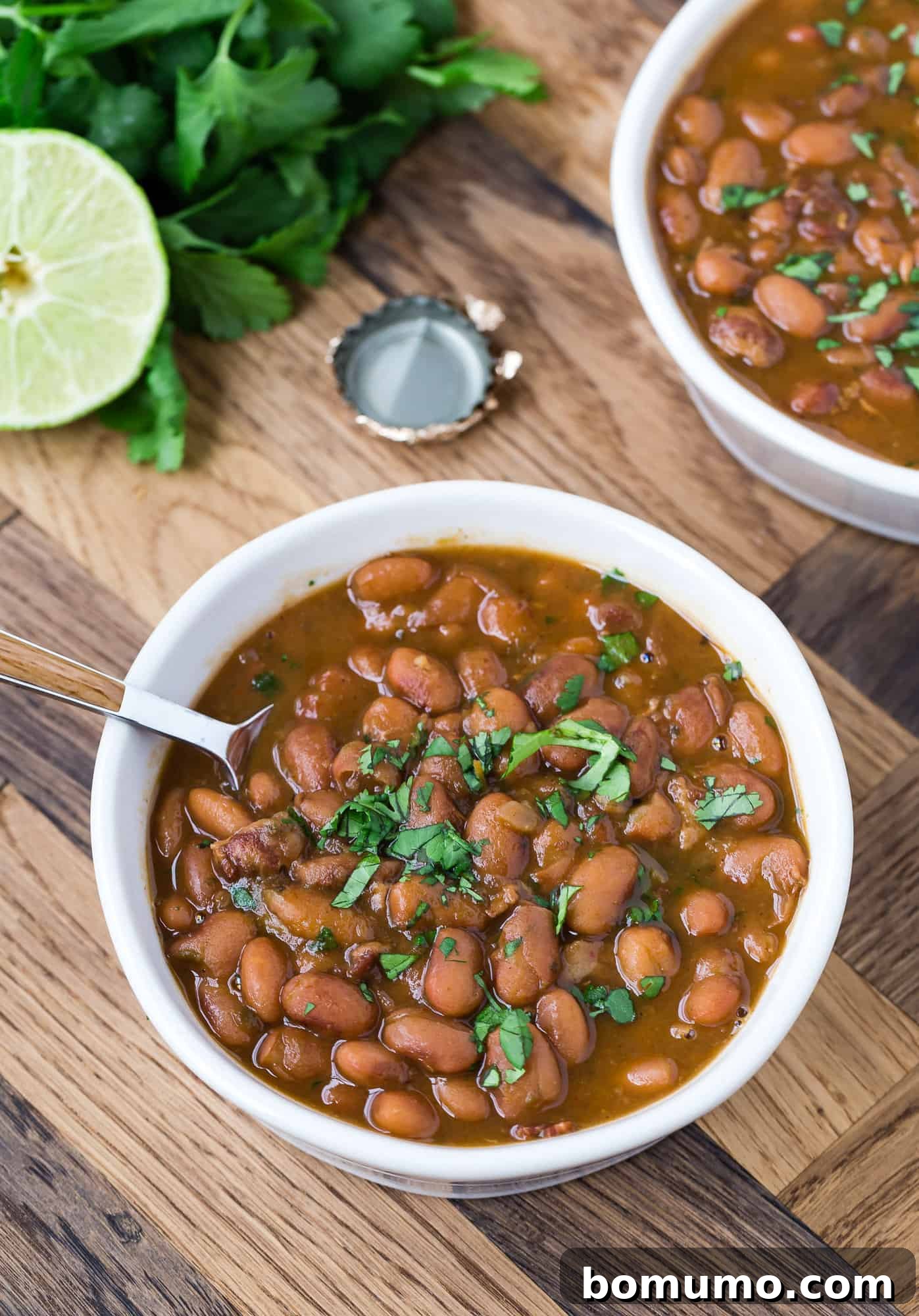 Drunken beans topped with cilantro in two bowls.