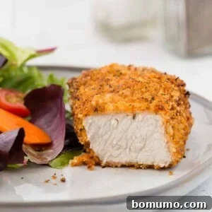 Air fryer breaded pork chop on a plate, cut to show meat.