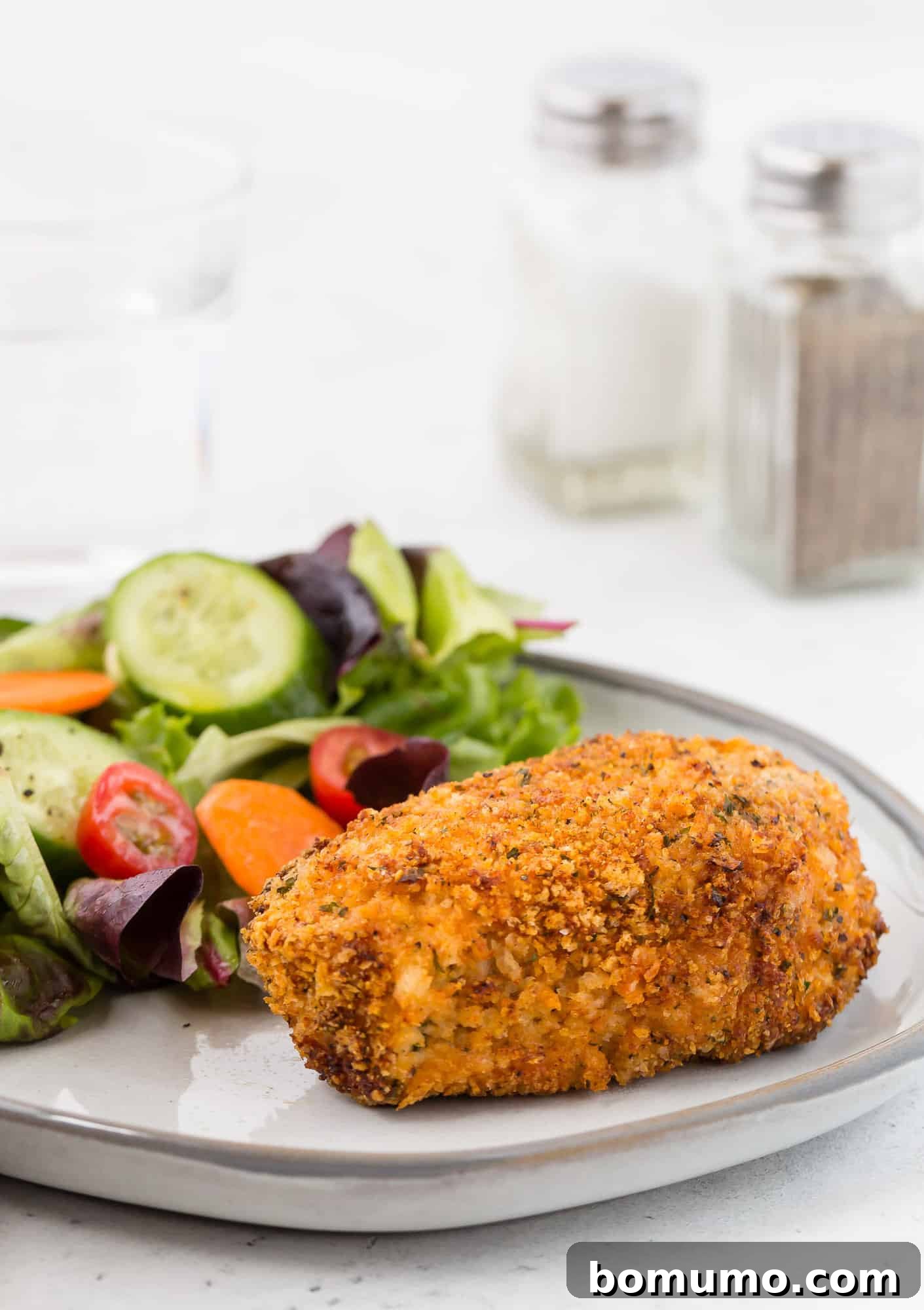 Golden brown breaded pork chop on a plate.