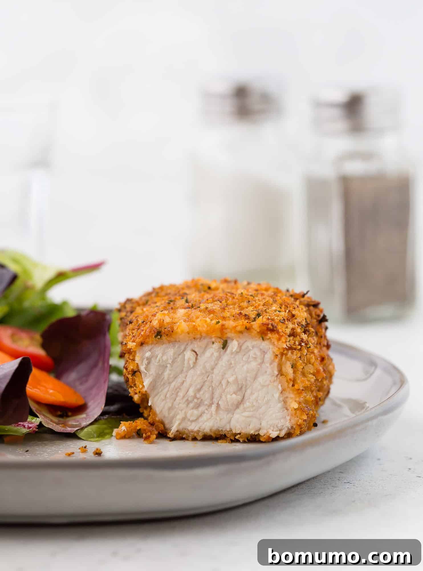 Pork chop, cut to show meat inside breading.