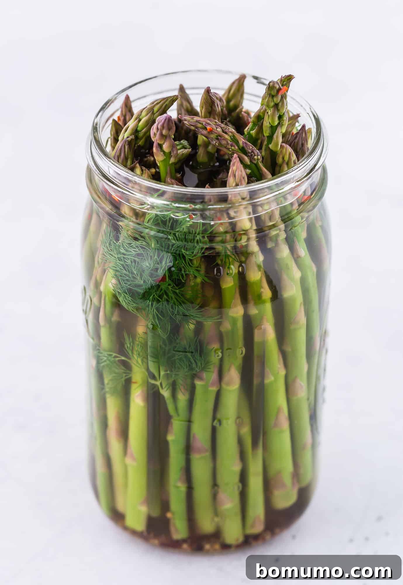 Image of asparagus pickles in a quart size mason jar.