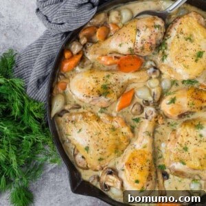 Chicken fricassee in a black skillet.