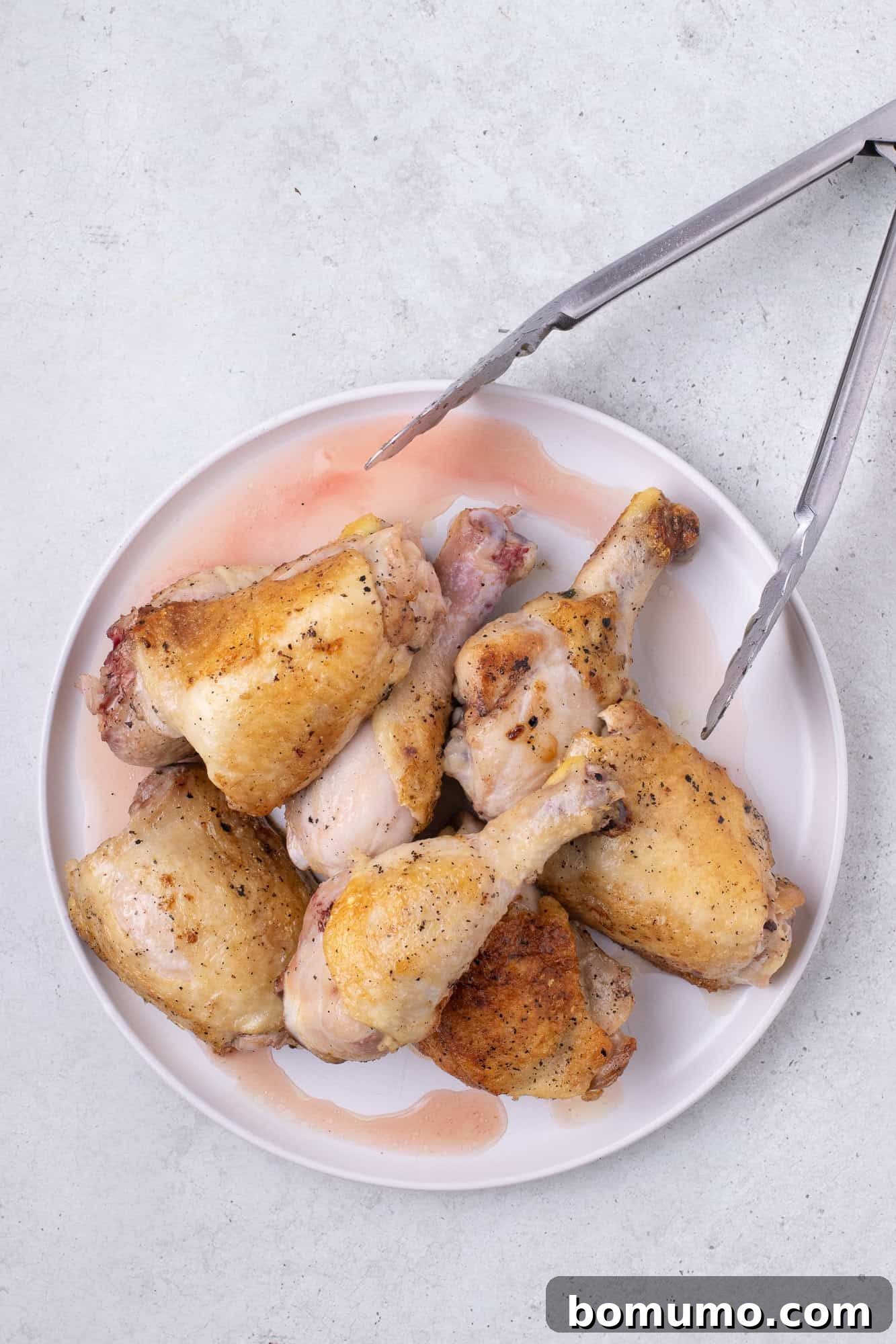 Perfectly browned chicken pieces removed from the skillet and resting on a plate.