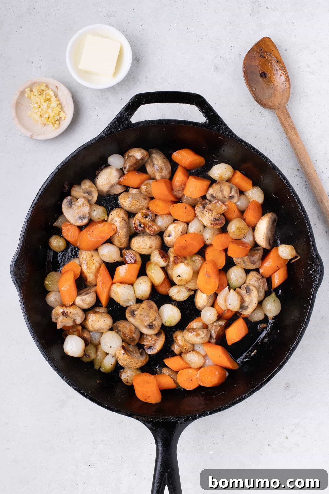 Sautéed vegetables in the skillet, having achieved a golden-brown color and softened texture.