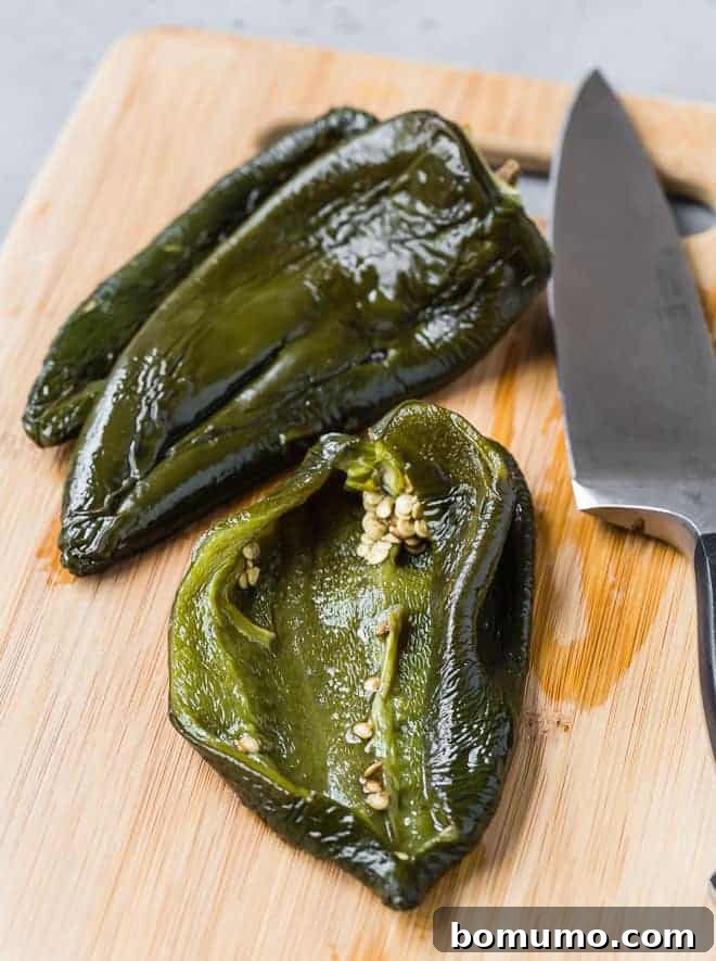 Poblano Perfection: 4 Roasting Methods 6 Image of roasted poblano peppers that have been peeled. One has been cut open to show the inside.