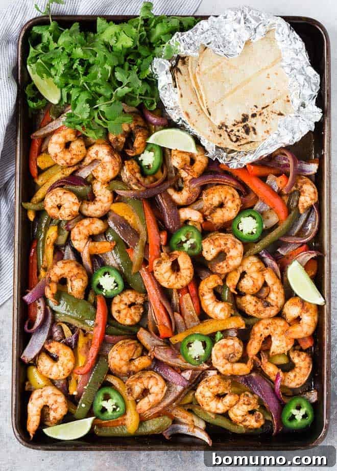 Sheet pan full of colorful vegetables and marinated shrimp.