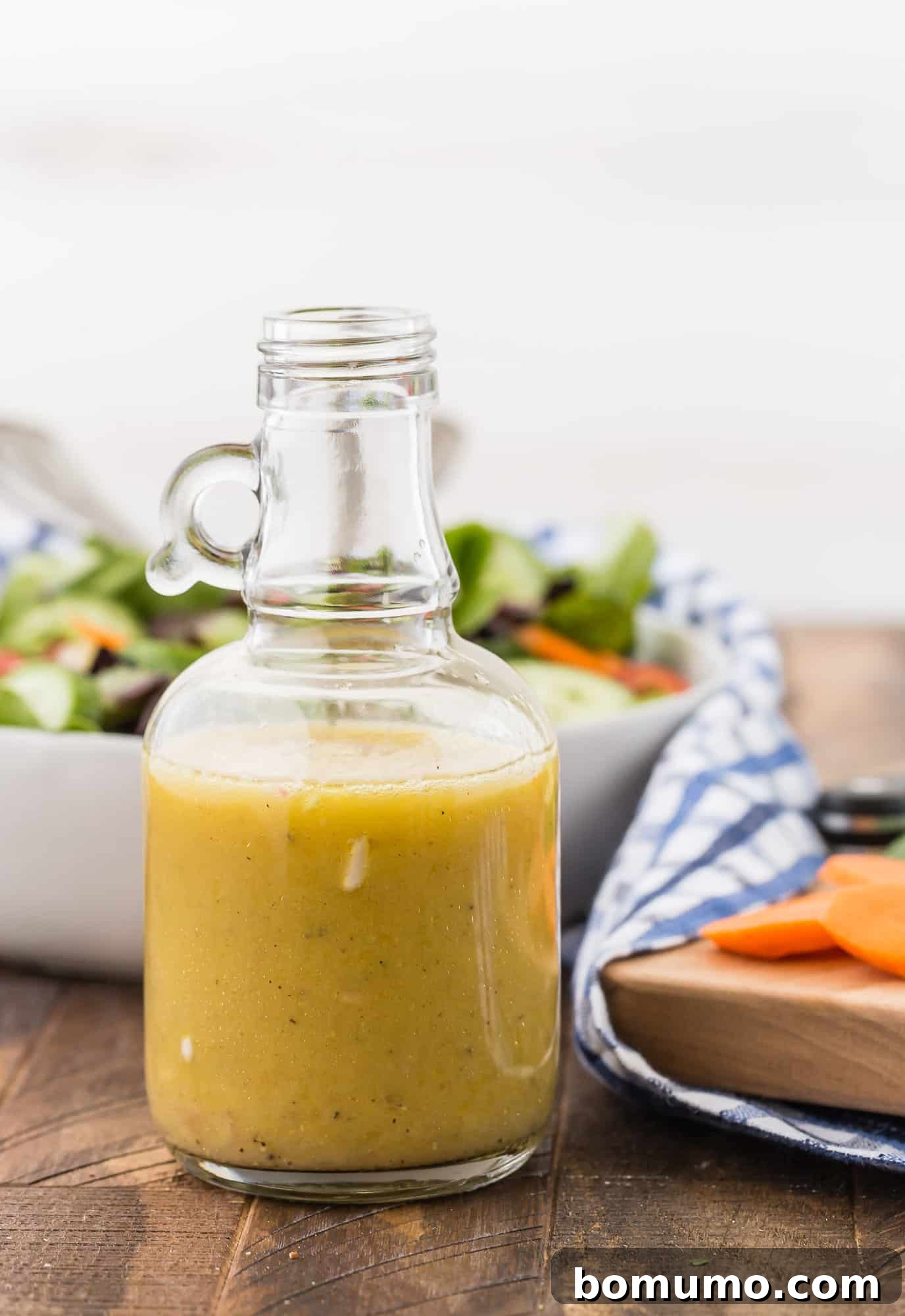 A vibrant green salad generously dressed with homemade white wine vinaigrette, suggesting freshness and flavor.