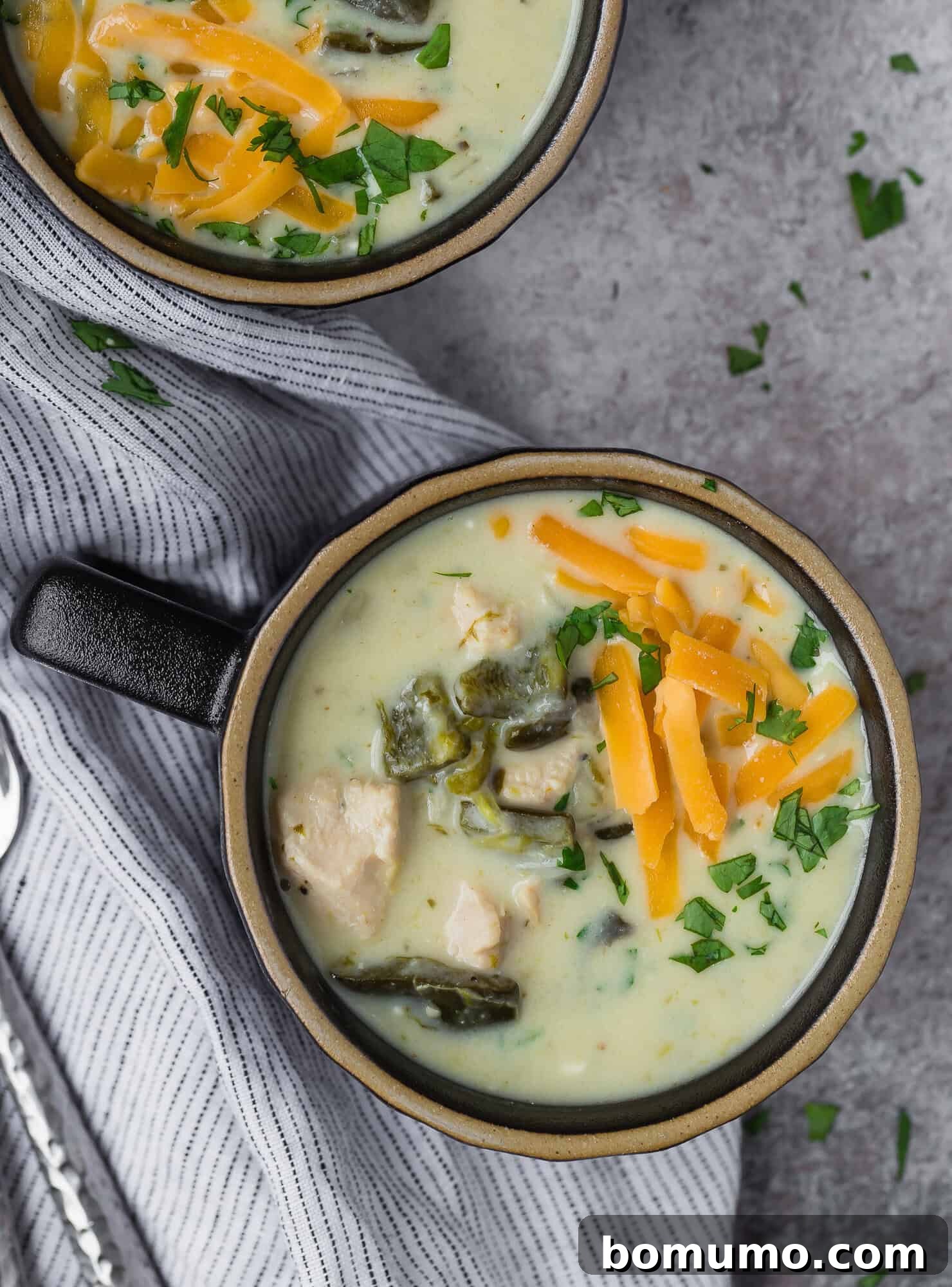 Overhead view of chile relleno soup, topped with cheddar cheese.