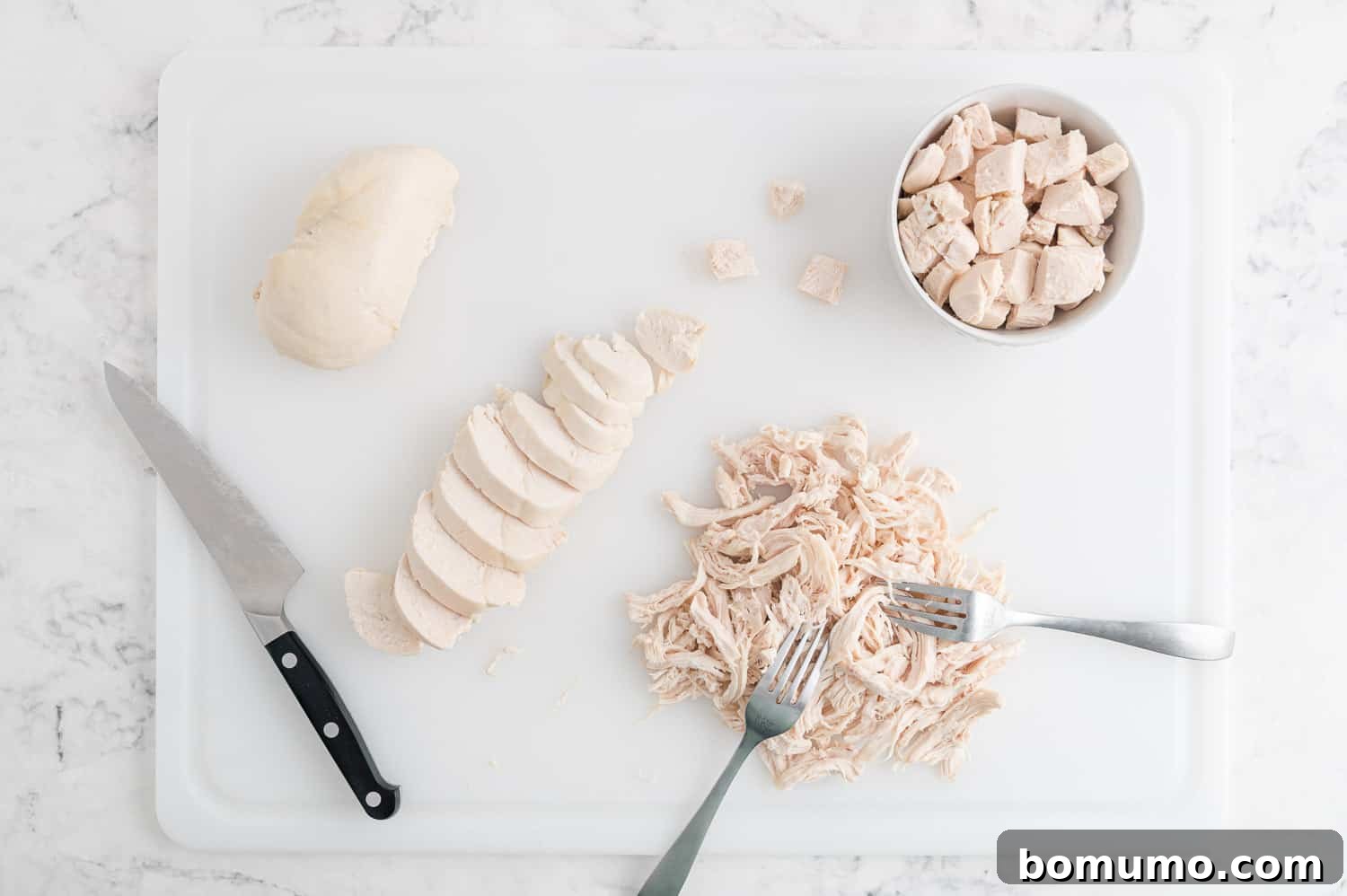 An array of poached chicken preparations: a whole breast, neatly sliced chicken, finely shredded chicken, and perfectly cubed chicken.