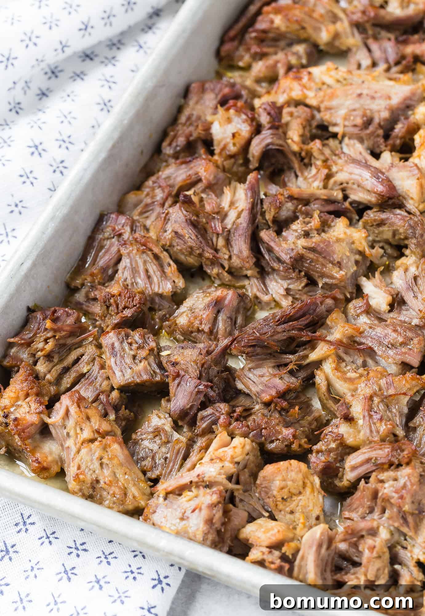 Carnitas, after crisping, on a sheet pan, showing the delicious, golden-brown edges.