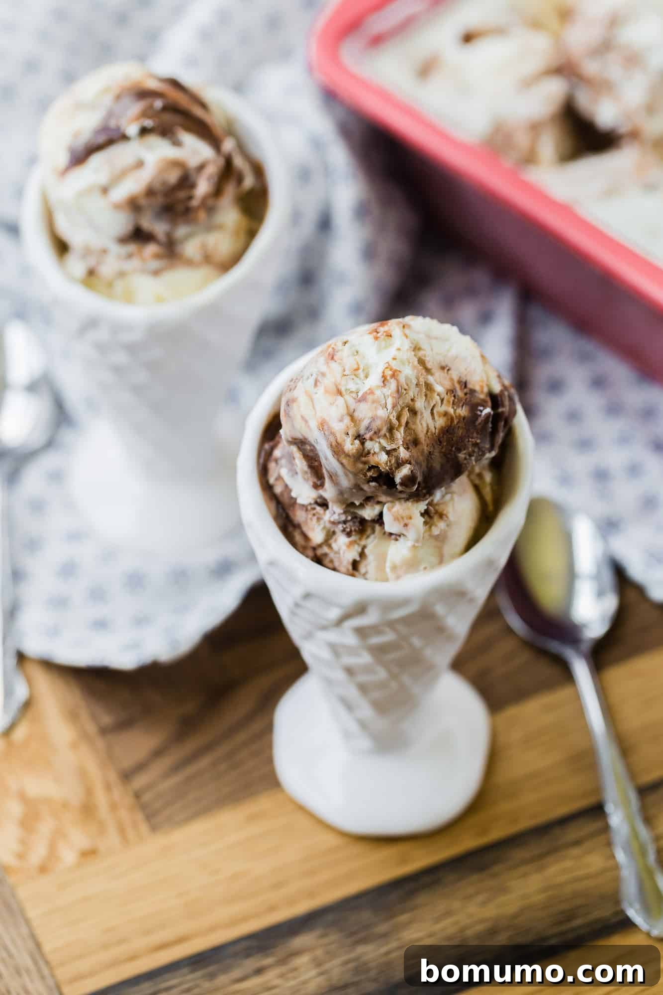 Ice cream in a white cone shaped bowl.