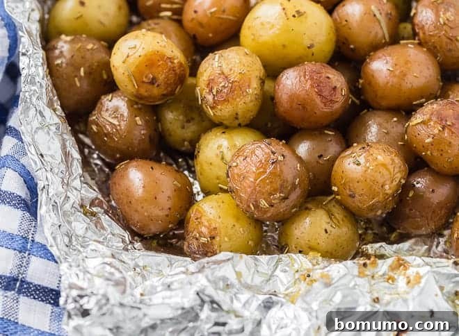 Landscape image of potatoes that have been grilled in a foil pack with rosemary.