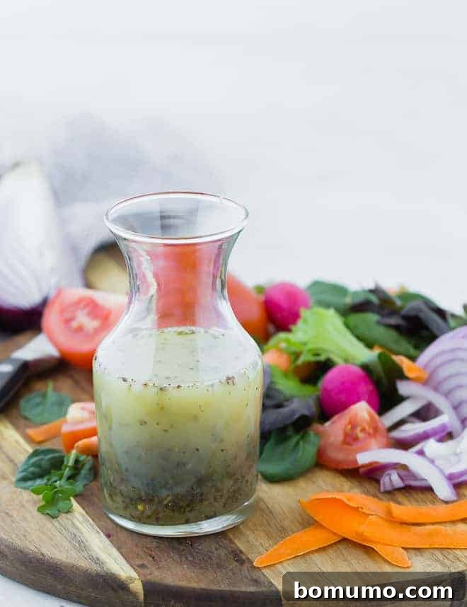 Authentic Italian Dressing from Scratch 6 Small glass bottle of homemade italian dressing on wooden cutting board surrounded by colorful vegetables.