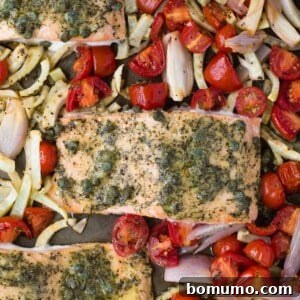 Close up view of perfectly roasted salmon with fresh dill and capers, surrounded by tender vegetables.