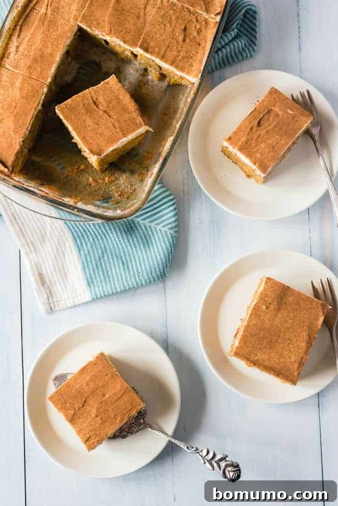 This pumpkin poke cake recipe is an easy fall dessert oozing with sweet cinnamon filling and smothered with tangy cream cheese frosting. Overhead view of multiple slices of pumpkin poke cake served on plates next to the rest of the cake in a pan.